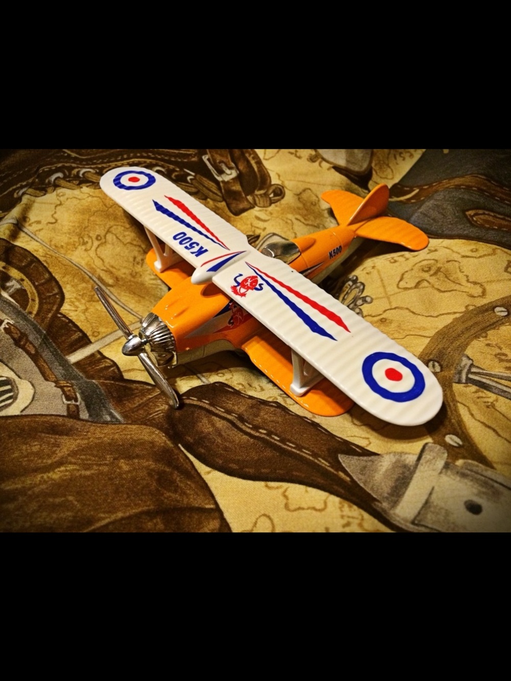 Orange and White Toy Biplane with Silver Propeller